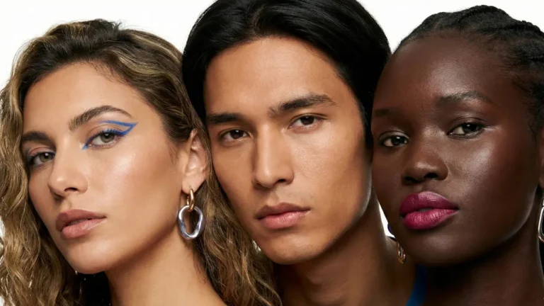 Três pessoas com diferentes tons de pele e maquiagens variadas olhando para a câmera, ilustrando a diversidade para o guia de como saber meu tipo de pele.